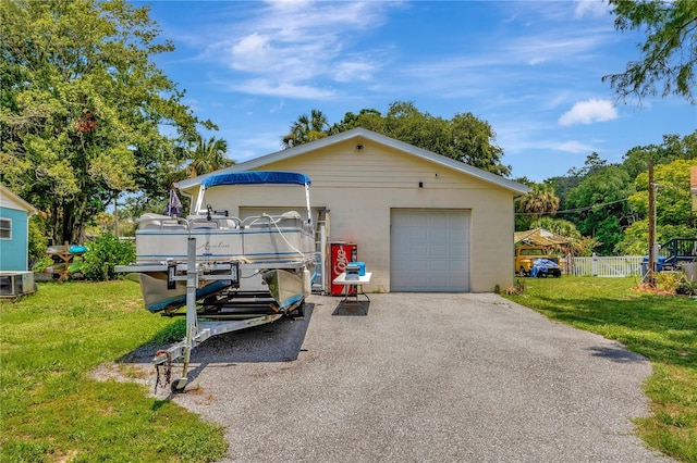 view of front of house with a garage, an outbuilding, and a front yard