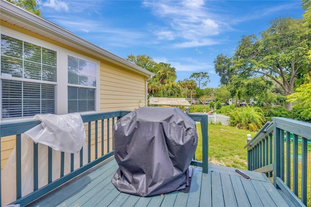 wooden deck with a lawn and grilling area