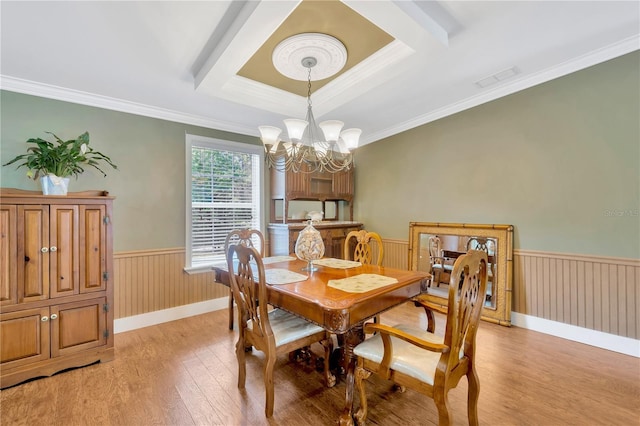 dining room with light hardwood / wood-style floors, a chandelier, and ornamental molding