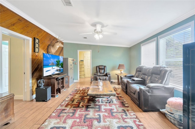 living room featuring crown molding, ceiling fan, light hardwood / wood-style floors, and wood walls