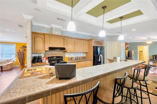 kitchen featuring a kitchen bar, ceiling fan, black appliances, and ornamental molding