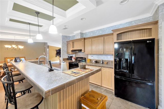 kitchen with black appliances, light brown cabinets, ornamental molding, and an island with sink