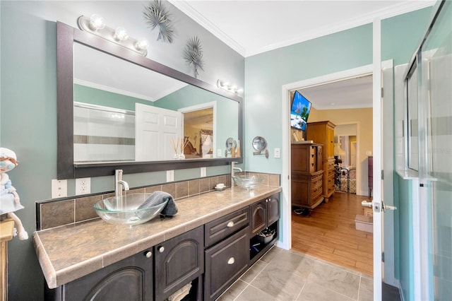 bathroom with tile patterned flooring, vanity, crown molding, and walk in shower