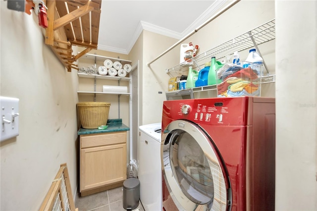 laundry area with cabinets, crown molding, light tile patterned floors, and washer and dryer