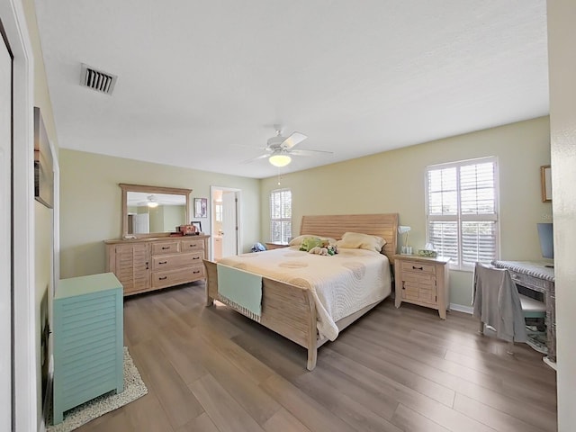 bedroom with ensuite bath, ceiling fan, and wood-type flooring