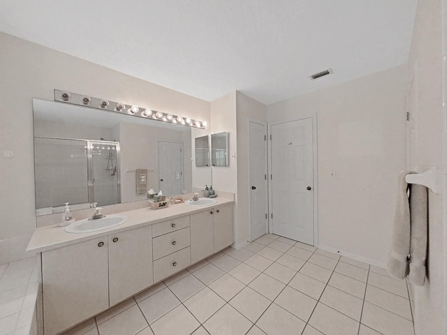 bathroom featuring tile patterned flooring, vanity, and walk in shower