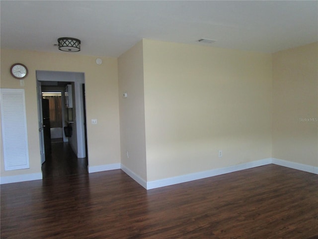 unfurnished room with dark wood-type flooring