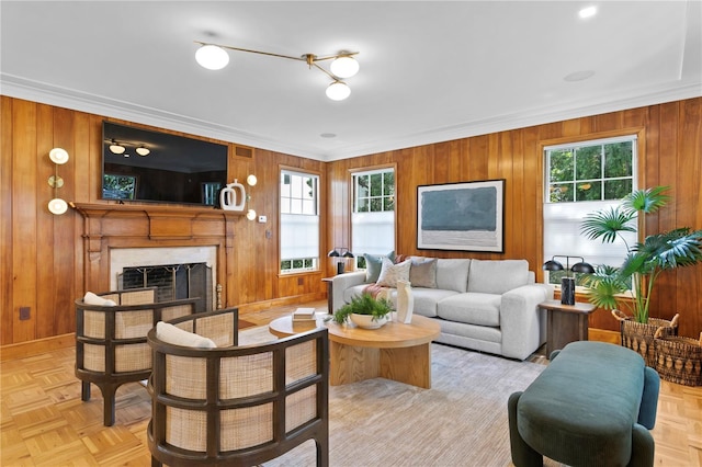 living room featuring crown molding, wood walls, and light parquet floors