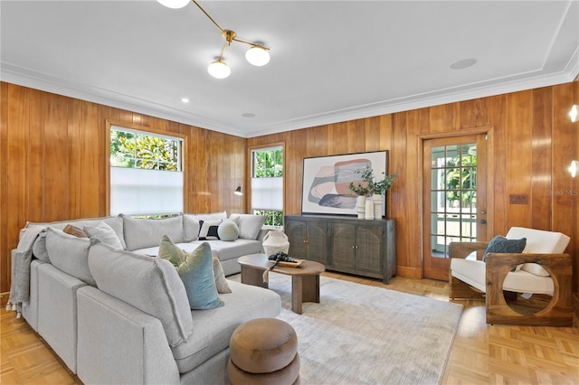 living room featuring light parquet flooring, crown molding, and wood walls