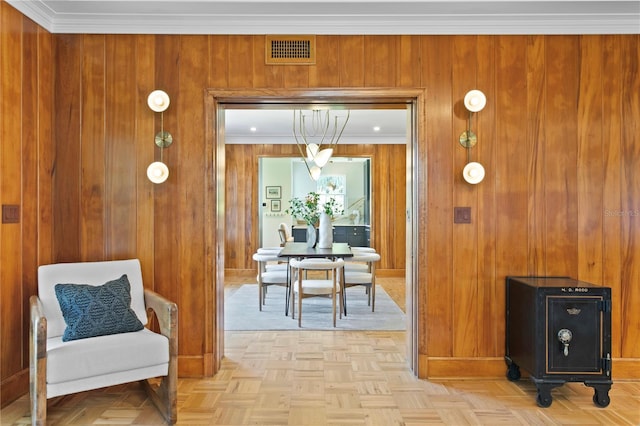 interior space featuring light parquet flooring, ornamental molding, and wooden walls