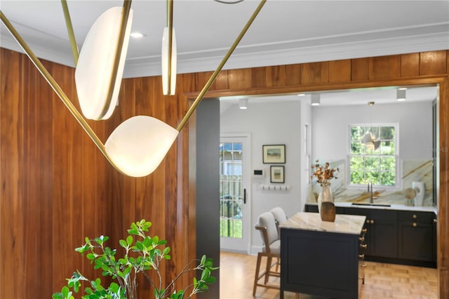 dining area with a healthy amount of sunlight, ornamental molding, and sink