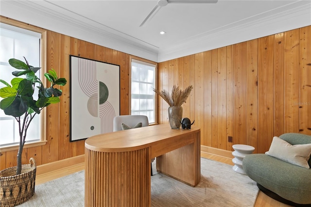 office area featuring crown molding, a wealth of natural light, light hardwood / wood-style flooring, and wood walls