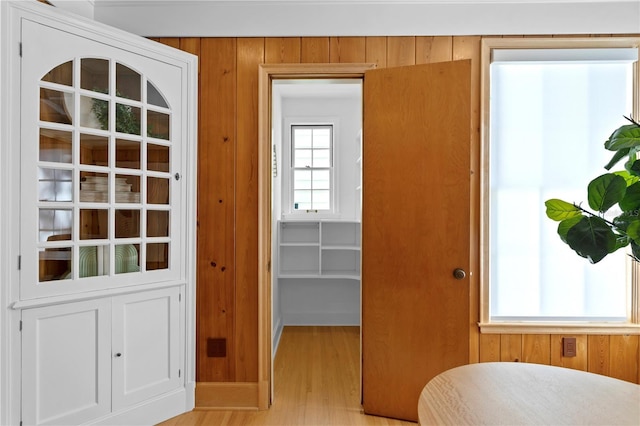 entryway with light hardwood / wood-style flooring and wood walls