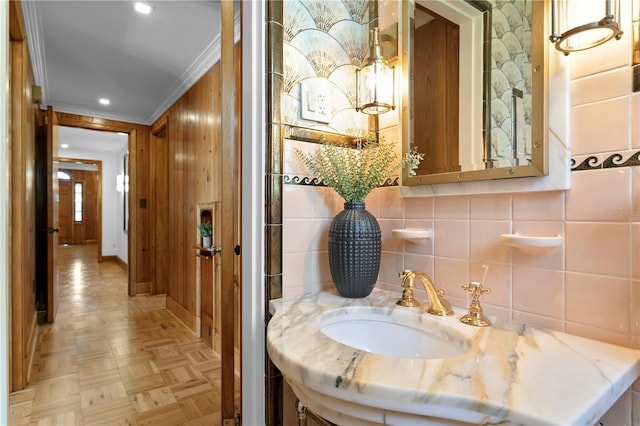 bathroom with parquet flooring, ornamental molding, and vanity