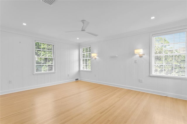 spare room with ornamental molding, ceiling fan, and light wood-type flooring