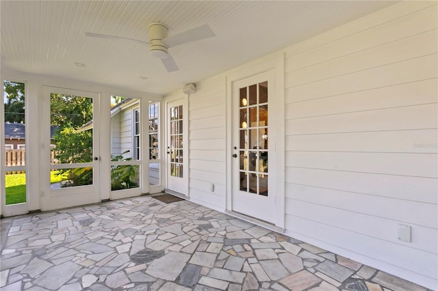 unfurnished sunroom featuring ceiling fan