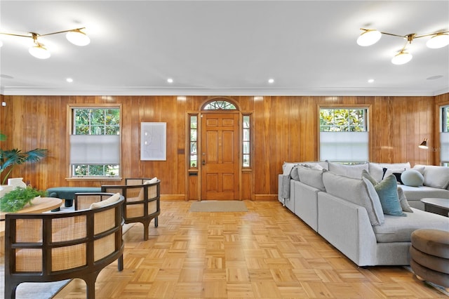 living room featuring ornamental molding, a healthy amount of sunlight, and light parquet flooring