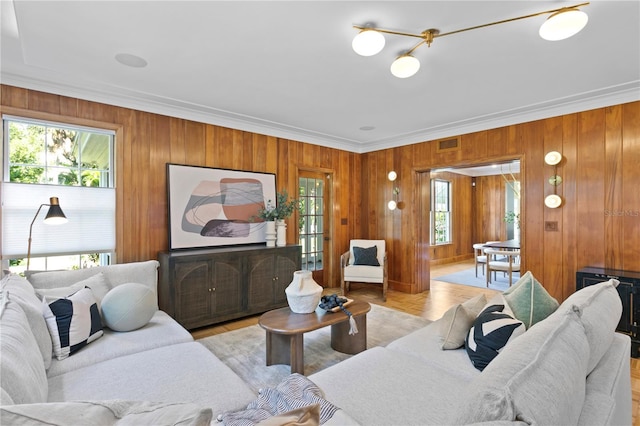 living room with crown molding and wood walls