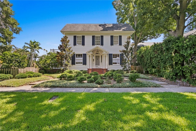 colonial inspired home featuring a front lawn