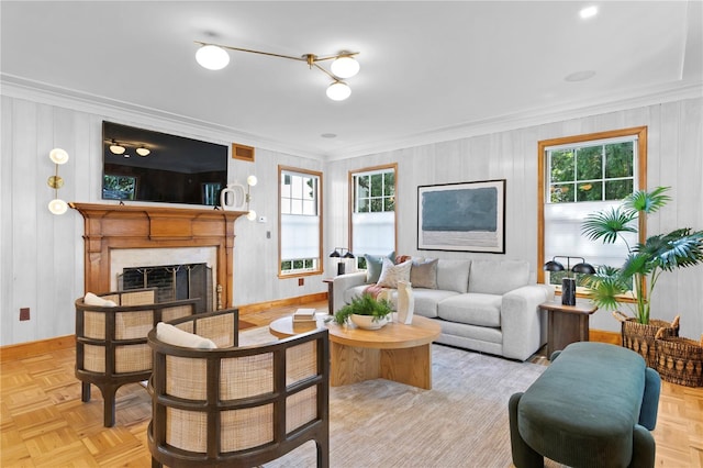 living room with light parquet floors, ornamental molding, and a high end fireplace