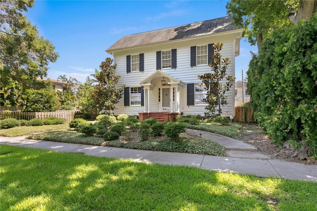 colonial-style house featuring a front yard