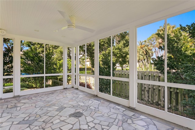 unfurnished sunroom with ceiling fan