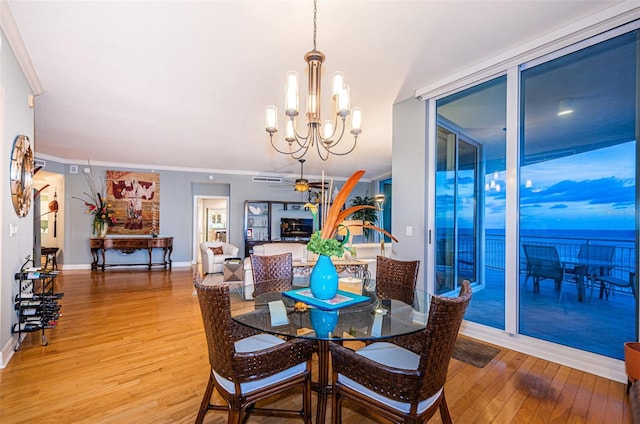 dining room featuring ceiling fan with notable chandelier, ornamental molding, and light hardwood / wood-style flooring