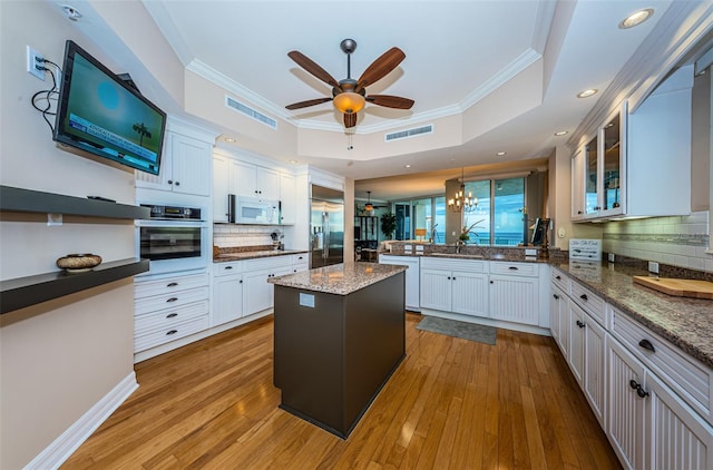 kitchen featuring tasteful backsplash, crown molding, light wood-type flooring, and appliances with stainless steel finishes