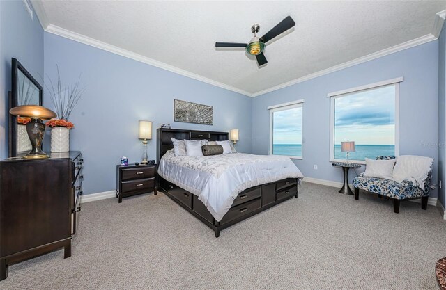 bedroom with a water view, ceiling fan, crown molding, light colored carpet, and a textured ceiling