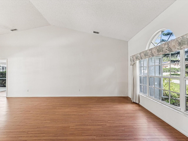 empty room featuring hardwood / wood-style flooring and lofted ceiling