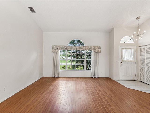 entryway featuring plenty of natural light, light wood-type flooring, and a notable chandelier