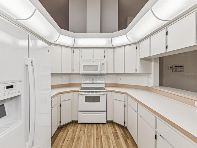 kitchen featuring light hardwood / wood-style flooring, white cabinets, and white appliances