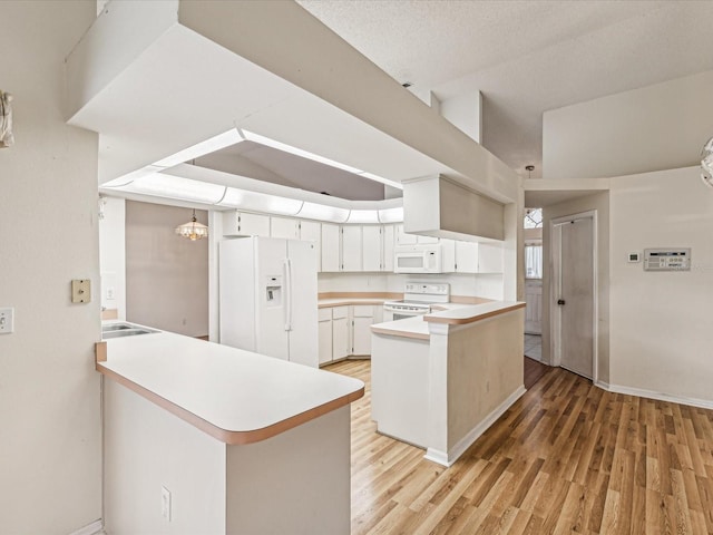 kitchen featuring kitchen peninsula, a textured ceiling, white appliances, light hardwood / wood-style flooring, and white cabinets