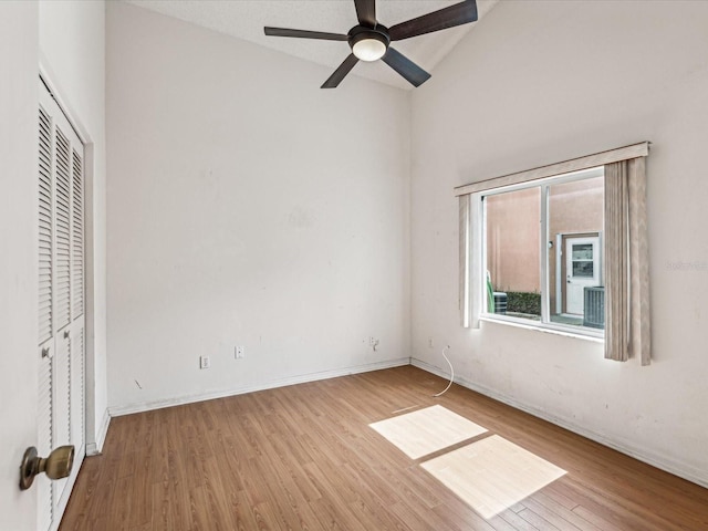 unfurnished bedroom featuring light wood-type flooring, a closet, vaulted ceiling, and ceiling fan