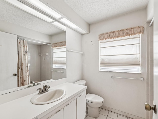 bathroom with tile patterned flooring, a textured ceiling, vanity, and toilet