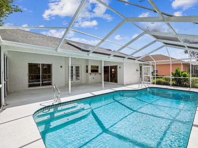 view of pool with glass enclosure, a patio, and french doors