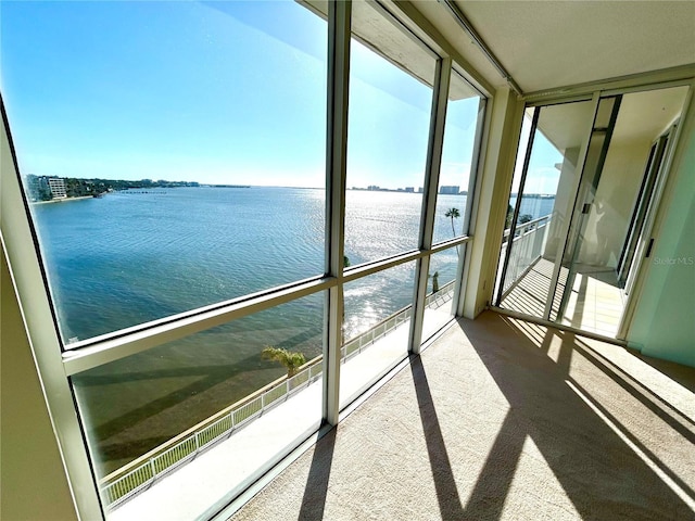 unfurnished sunroom with a healthy amount of sunlight and a water view