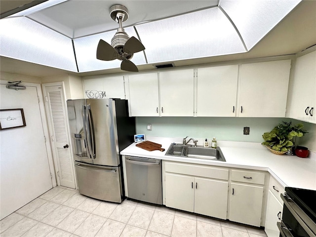 kitchen with hanging light fixtures, stainless steel appliances, white cabinets, ceiling fan, and sink