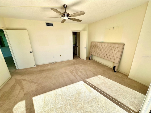 carpeted bedroom with a textured ceiling and ceiling fan