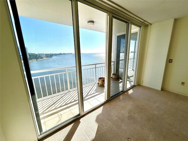 doorway to outside with carpet floors and a water view