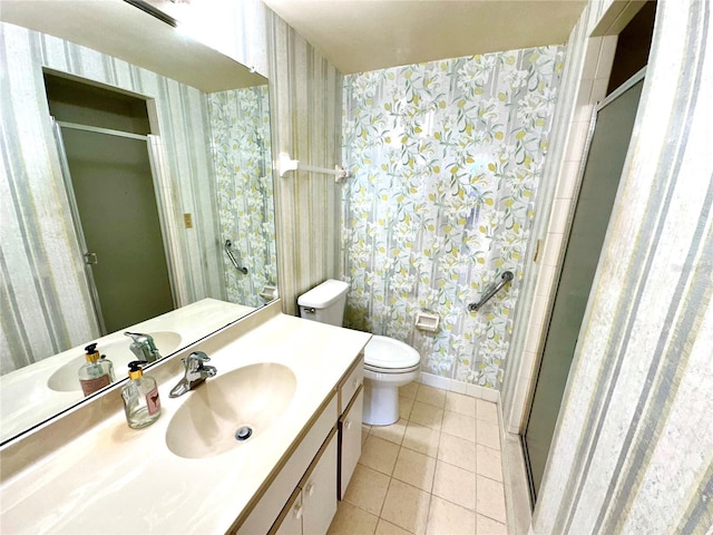 bathroom with toilet, tile patterned flooring, a shower with shower door, and vanity