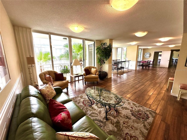 living room with a textured ceiling, expansive windows, and wood-type flooring