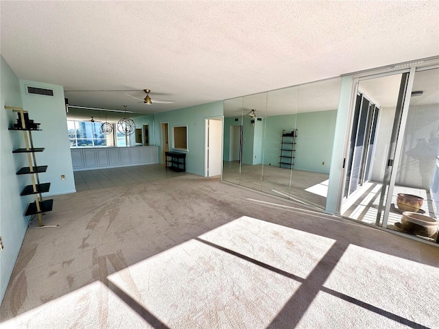 carpeted empty room with a textured ceiling and ceiling fan