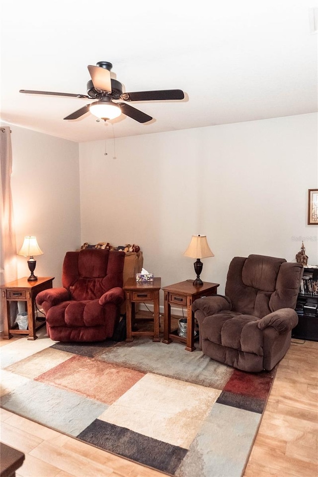 living room featuring wood-type flooring and ceiling fan