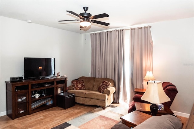 living room featuring light hardwood / wood-style flooring and ceiling fan