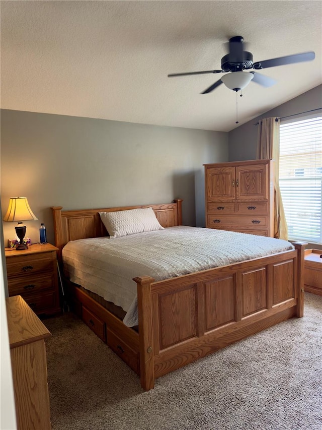 bedroom with a textured ceiling, carpet, vaulted ceiling, and ceiling fan