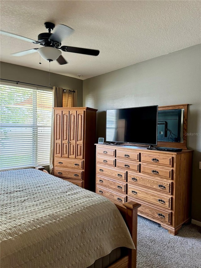 carpeted bedroom with a textured ceiling and ceiling fan