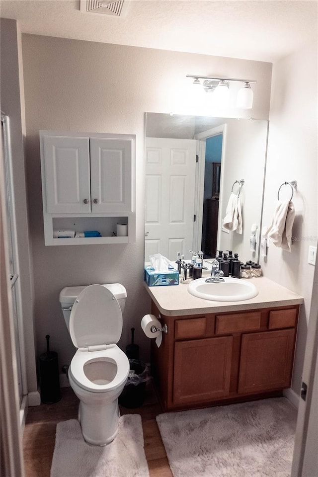 bathroom featuring vanity, toilet, and hardwood / wood-style floors