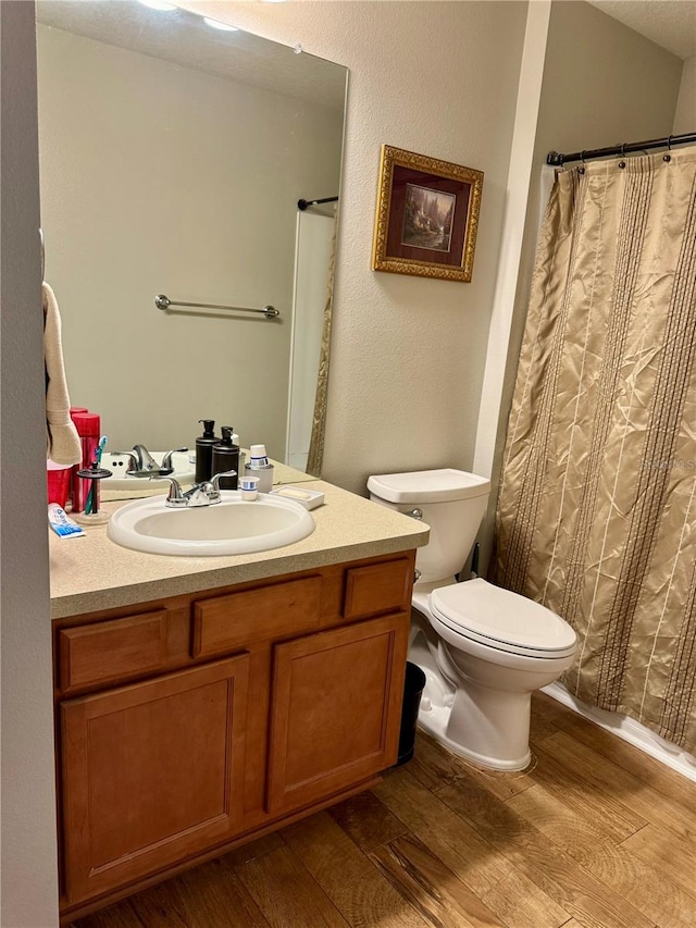 bathroom with vanity, hardwood / wood-style flooring, and toilet