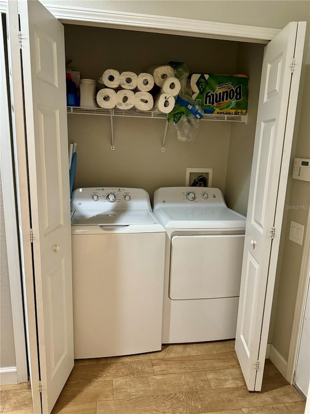 washroom featuring light hardwood / wood-style floors and washing machine and dryer